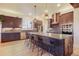 Open kitchen with an oversized center island, stainless steel appliances, and barstool seating at 4950 Saddle Iron Rd, Castle Rock, CO 80104