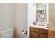 Clean and simple half bathroom with wood vanity and single sink at 1411 Maple Dr, Berthoud, CO 80513