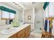 Bathroom with double sinks, bathtub, and shower at 1411 Maple Dr, Berthoud, CO 80513