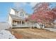 Two-story house with white siding, covered porch, and mature tree in front at 1411 Maple Dr, Berthoud, CO 80513