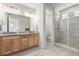 Bathroom with double sinks, granite countertops, and a glass enclosed shower at 2641 Channel Dr, Highlands Ranch, CO 80129