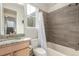 Bright bathroom featuring a shower with gray tile, a vanity with granite counters at 2641 Channel Dr, Highlands Ranch, CO 80129