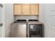 Laundry room with front-loading washer and dryer and upper cabinets for storage at 2641 Channel Dr, Highlands Ranch, CO 80129