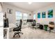 Bright home office featuring dual workstations, plush carpet, and stunning lake views from large windows at 2641 Channel Dr, Highlands Ranch, CO 80129