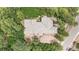 An aerial view of home showing tile roof and mature landscaping, surrounded by lush trees and a patio area at 209 Saratoga Mine Dr, Castle Rock, CO 80108