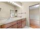 Bathroom featuring double sinks, wood cabinets, and an oversized mirror at 209 Saratoga Mine Dr, Castle Rock, CO 80108