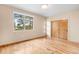 Bedroom featuring hardwood floors, a large window, and a closet with wood doors at 209 Saratoga Mine Dr, Castle Rock, CO 80108