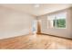 Bright bedroom featuring hardwood floors, a large window with blinds, and an ensuite bathroom at 209 Saratoga Mine Dr, Castle Rock, CO 80108