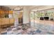 Open-concept living space with stone tile flooring connecting the kitchen and living room at 209 Saratoga Mine Dr, Castle Rock, CO 80108