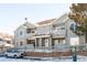 View of gray two story townhome exterior with patios, brick accents, and a gray fence in a snowy landscape at 912 S Yampa St # 206, Aurora, CO 80017