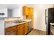 Kitchen with stainless steel dishwasher, sink, and faucet, and warm wood cabinets and a stainless steel refrigerator at 912 S Yampa St # 206, Aurora, CO 80017