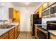 Galley kitchen with stainless steel appliances and a stainless steel double sink with warm wood cabinets at 912 S Yampa St # 206, Aurora, CO 80017