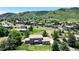 Aerial shot showcasing the property's prime location amidst lush greenery, mountains, and upscale neighborhood at 10886 Pheasant Run, Littleton, CO 80125