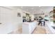 Spacious kitchen flowing into the dining and living areas, featuring white cabinets and modern appliances at 10886 Pheasant Run, Littleton, CO 80125