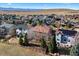 An aerial view of a neighborhood with houses, mature trees, fences, and a scenic mountain backdrop at 1788 Alpine Dr, Erie, CO 80516