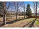 Large backyard with a wooden fence and mature trees, offering a private outdoor space to relax and enjoy at 1788 Alpine Dr, Erie, CO 80516