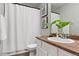 Bathroom with a modern sink, shower curtain, decorative plants, and stylish decor creating a serene atmosphere at 1788 Alpine Dr, Erie, CO 80516