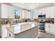 Stylish kitchen with granite countertops, stainless appliances, tiled backsplash, and white cabinets at 1788 Alpine Dr, Erie, CO 80516