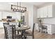 Open kitchen and eat-in area with island, modern lighting, and built-in desk at 1788 Alpine Dr, Erie, CO 80516