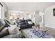 Open-concept living room featuring leather furniture, area rug, and access to kitchen at 1788 Alpine Dr, Erie, CO 80516
