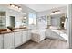 Large main bathroom boasts dual sinks, a soaking tub, and lots of natural light, creating a luxurious space at 1788 Alpine Dr, Erie, CO 80516