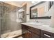 Modern bathroom featuring a tiled walk-in shower and vanity with a sink and mirror at 1819 W 32Nd Ave, Denver, CO 80211