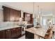 A kitchen with a granite island, stainless steel appliances, dark brown cabinets, and modern pendant lighting at 1819 W 32Nd Ave, Denver, CO 80211