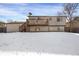 A two-story home featuring a wooden deck and a snow-covered backyard at 16651 E Arizona Pl, Aurora, CO 80017