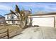 Home exterior showcasing a two-car garage, brick accents, and mature trees at 16651 E Arizona Pl, Aurora, CO 80017