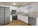Well-lit kitchen with stainless steel appliances, white cabinetry, and marble-pattern countertops at 16651 E Arizona Pl, Aurora, CO 80017