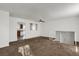 Open-concept living room with neutral carpet, and staircase access, leading to a glimpse of the adjacent kitchen at 16651 E Arizona Pl, Aurora, CO 80017