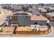 Aerial view of a gray two-story home with a fenced backyard and solar panels at 9976 E 63Rd Ave, Denver, CO 80238