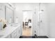 Modern bathroom featuring dual vanity, glass shower, and view into the bedroom at 9976 E 63Rd Ave, Denver, CO 80238