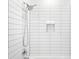 Modern bathroom shower featuring white subway tile and a recessed storage niche at 9976 E 63Rd Ave, Denver, CO 80238