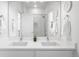 Modern bathroom with double sink vanity, large mirror, and tiled shower at 9976 E 63Rd Ave, Denver, CO 80238
