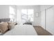 Bright bedroom with large window, bench, and sliding closet doors at 9976 E 63Rd Ave, Denver, CO 80238