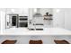 Spacious, bright kitchen with stainless steel appliances, quartz countertops, and a large center island at 9976 E 63Rd Ave, Denver, CO 80238