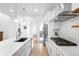 Modern kitchen featuring white cabinets, stainless appliances, and a long island, bathed in natural light at 9976 E 63Rd Ave, Denver, CO 80238