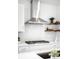 Close-up of a modern kitchen with a stainless steel hood and stylish tile backsplash at 9976 E 63Rd Ave, Denver, CO 80238