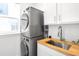 Convenient laundry room with stacked washer and dryer and utility sink at 9976 E 63Rd Ave, Denver, CO 80238