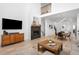 Open-concept living space featuring a fireplace and seamless flow to the dining area at 9976 E 63Rd Ave, Denver, CO 80238