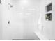 Bright, tiled shower with sleek fixtures and convenient shelving at 9976 E 63Rd Ave, Denver, CO 80238