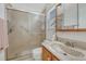 Cozy bathroom with walk-in shower, glass doors, grab bar, and single sink vanity at 5160 Hannibal St, Denver, CO 80239