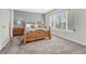 A spacious bedroom features a wooden bed frame and light-filled view from the window at 5160 Hannibal St, Denver, CO 80239