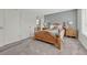 Bedroom with oak bed, side tables, and dresser with ensuite bath behind white door at 5160 Hannibal St, Denver, CO 80239