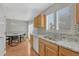 Kitchen with oak cabinets, stainless sink, mosaic backsplash, and adjacent dining area with chandelier at 5160 Hannibal St, Denver, CO 80239
