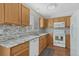 A well-lit kitchen features oak cabinets and modern white appliances with a mosaic backsplash at 5160 Hannibal St, Denver, CO 80239