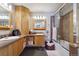 Modern bathroom featuring double sinks, updated vanity, and bathtub with glass door at 4011 W Kenyon Ave, Denver, CO 80236