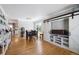 Dining area with a modern chandelier, table with chairs, hardwood floors, and custom-built shelving at 4011 W Kenyon Ave, Denver, CO 80236