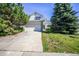 Charming two-story home featuring a two-car garage, well-maintained lawn, and mature trees on a sunny day at 11305 W Crestline Dr, Littleton, CO 80127